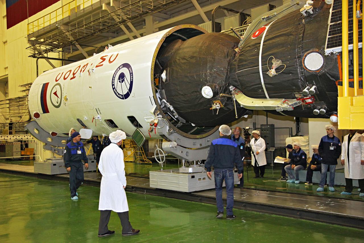 jsc2017e044351 (April 12, 2017) --- In the Integration Facility at the Baikonur Cosmodrome in Kazakhstan, the Soyuz MS-04 spacecraft is encapsulated into the upper stage of a Soyuz booster rocket April 12 as technicians look on. The operation took place on the 56th anniversary of the launch of Yuri Gagarin from Baikonur to become the first human to fly in space. Expedition 51 crewmembers Fyodor Yurchikhin of the Russian Federal Space Agency (Roscosmos) and Jack Fischer of NASA will launch April 20 on the Soyuz MS-04 spacecraft from Baikonur for a four and a half month mission on the International Space Station. Photo Credit: (Roscosmos)