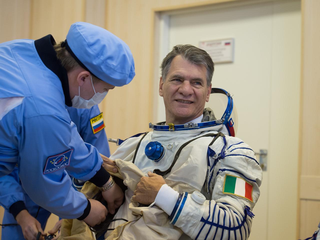 jsc2017e096659 (July 17, 2017) --- In the Integration Facility at the Baikonur Cosmodrome in Kazakhstan, Expedition 52-53 crewmember Paolo Nespoli of the European Space Agency suits up in his Russian Sokol launch and entry suit during a fit check dress rehearsal July 17. Nespoli, Randy Bresnik of NASA and Sergey Ryazanskiy of the Russian Federal Space Agency (Roscosmos) will launch July 28 on the Soyuz MS-05 spacecraft for a five-month mission on the International Space Station. Credit: Andrey Shelepin/Gagarin Cosmonaut Training Center