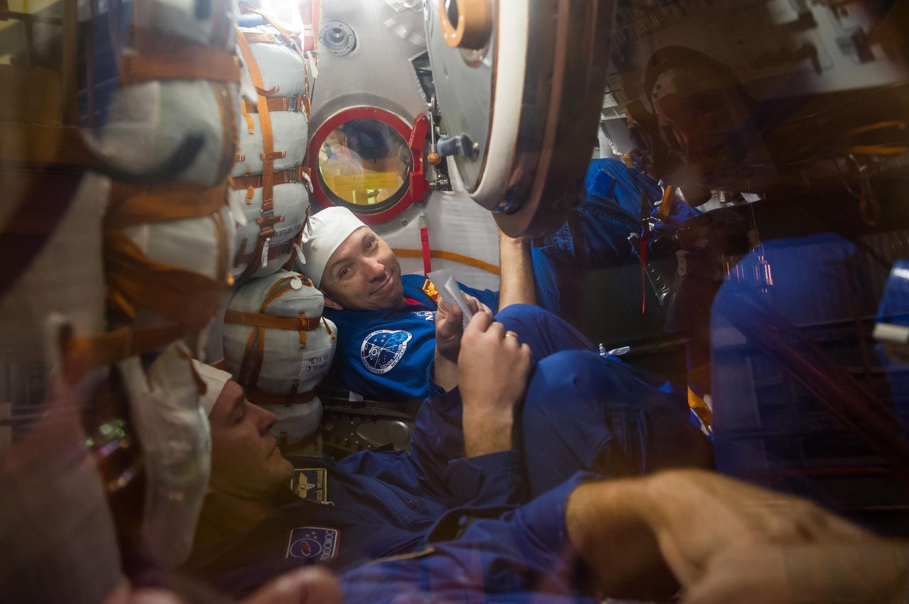jsc2017e096666 (July 17, 2017) --- In the Integration Facility at the Baikonur Cosmodrome in Kazakhstan, Expedition 52-53 crewmember Randy Bresnik of NASA (right) flashes a smile inside the Soyuz MS-05 spacecraft July 17 while seated next to his crewmate, Sergey Ryazanskiy of the Russian Federal Space Agency (Roscosmos) during a fit check dress reheasal. Bresnik, Ryazanskiy and Paolo Nespoli of the European Space Agency will launch July 28 on the Soyuz MS-05 spacecraft for a five-month mission on the International Space Station. Credit: Andrey Shelepin/Gagarin Cosmonaut Training Center