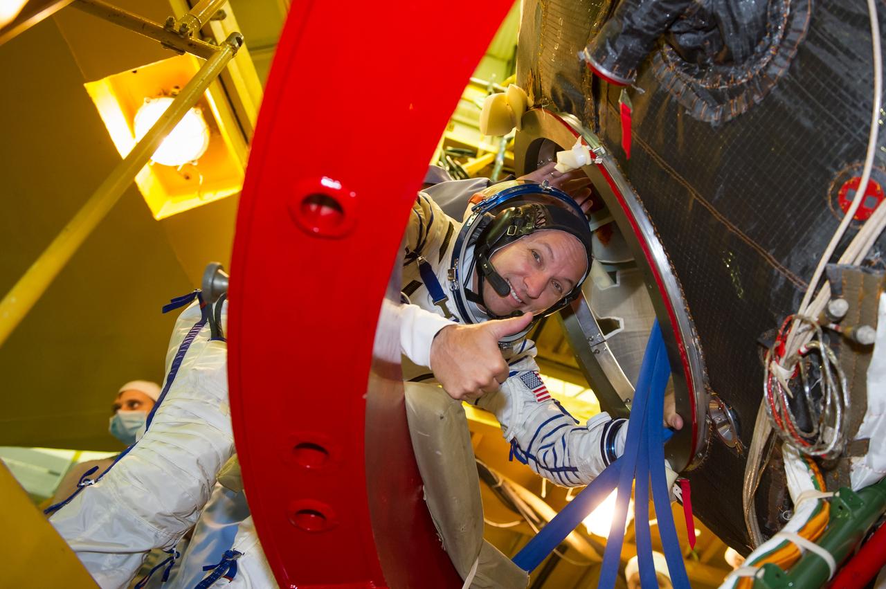 jsc2017e096672 (July 17, 2017) --- In the Integration Facility at the Baikonur Cosmodrome in Kazakhstan, Expedition 52-53 crewmember Randy Bresnik of NASA flashes a smile as he enters the Soyuz MS-05 spacecraft July 17 during a fit check dress rehearsal. Bresnik, Sergey Ryazanskiy of the Russian Federal Space Agency (Roscosmos) and Paolo Nespoli of the European Space Agency will launch July 28 on the Soyuz MS-05 spacecraft for a five-month mission on the International Space Station. Credit: Andrey Shelepin/Gagarin Cosmonaut Training Center
