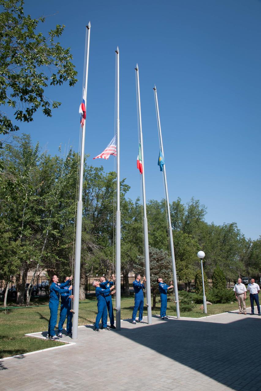 jsc2017e100897 (July 18, 2017) --- At the Cosmonaut Hotel crew quarters in Baikonur, Kazakhstan, the Expedition 52-53 prime and backup crewmembers raised the flags of the U.S., Russia, Italy and Kazakhstan July 18 during traditional pre-launch ceremonies. From left to right are Sergey Ryazanskiy and Alexander Misurkin of the Russian Federal Space Agency (Roscosmos) raising the Russian flag, Mark Vande Hei and Randy Bresnik of NASA raising the U.S. flag, Paolo Nespoli of the European Space Agency raising the flag of Italy and Norishige Kanai of the Japan Aerospace Exploration Agency (JAXA) raising the flag of Kazakhstan. Ryazanskiy, Bresnik and Nespoli will launch July 28 on the Soyuz MS-05 spacecraft from the Baikonur Cosmodrome for a five-month mission on the International Space Station. Credit: NASA/Victor Zelentsov