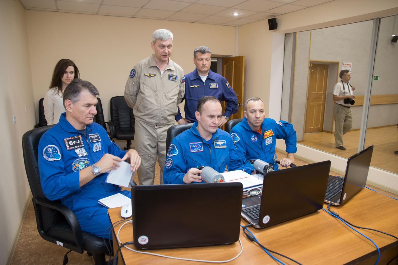jsc2017e101940 (July 22, 2017) --- At the Cosmonaut Hotel crew quarters in Baikonur, Kazakhstan, Expedition 52-53 crewmembers Paolo Nespoli of the European Space Agency (left), Sergey Ryazanskiy of the Russian Federal Space Agency (Roscosmos, center) and Randy Bresnik of NASA (right) brush up on rendezvous procedures on a laptop computer simulator July 22 as part of their pre-launch activities. Ryazanskiy, Bresnik and Nespoli will launch July 28 on the Soyuz MS-05 spacecraft from the Baikonur Cosmodrome for a five-month mission on the International Space Station. Credit: NASA/Victor Zelentsov