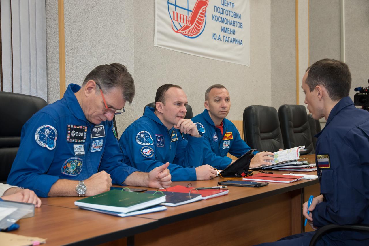 jsc2017e101941 (July 22, 2017) --- At the Cosmonaut Hotel crew quarters in Baikonur, Kazakhstan, Expedition 52-53 crewmembers Paolo Nespoli of the European Space Agency (left), Sergey Ryazanskiy of the Russian Federal Space Agency (Roscosmos, center) and Randy Bresnik of NASA (right) listen to a training instructor July 22 as part of their pre-launch activities. Ryazanskiy, Bresnik and Nespoli will launch July 28 on the Soyuz MS-05 spacecraft from the Baikonur Cosmodrome for a five-month mission on the International Space Station. Credit: NASA/Victor Zelentsov