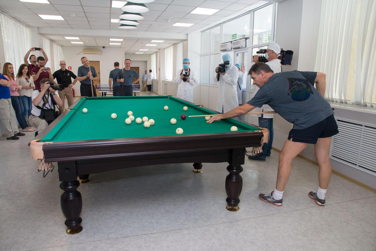 jsc2017e101944 (July 22, 2017) --- At the Cosmonaut Hotel crew quarters in Baikonur, Kazakhstan, Expedition 52-53 crewmember Paolo Nespoli of the European Space Agency tries his hand at billiards July 22 as his crewmates at the far end of the table, Randy Bresnik of NASA (left) and Sergey Ryazanskiy of the Russian Federal Space Agency (Roscosmos, right) look on. The trio will launch July 28 on the Soyuz MS-05 spacecraft from the Baikonur Cosmodrome for a five-month mission on the International Space Station. Credit: NASA/Victor Zelentsov