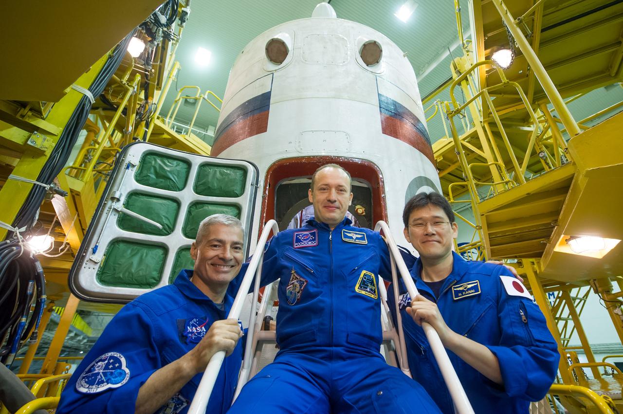 jsc2017e101958 (July 22, 2017) --- In the Integration Facility at the Baikonur Cosmodrome in Kazakhstan, Expedition 52-53 backup crewmembers Mark Vande Hei of NASA (left), Alexander Misurkin of the Russian Federal Space Agency (Roscosmos, center) and Norishige Kanai of the Japan Aerospace Exploration Agency (JAXA, right) pose for pictures in front of the Soyuz MS-05 spacecraft July 24 during their final fit check dress rehearsal. They are serving as the backups to Randy Bresnik of NASA, Sergey Ryazanskiy of Roscosmos and Paolo Nespoli of the European Space Agency, who will launch July 28 aboard the Soyuz MS-05 spacecraft for a five-month mission on the International Space Station. Credit: Andrey Shelepin/Gagarin Cosmonaut Training Center
