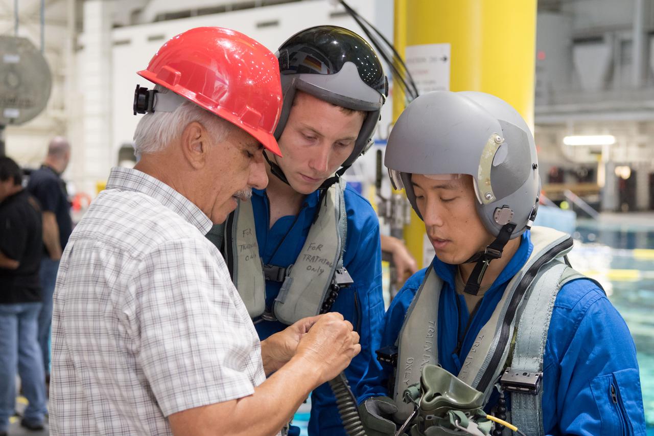 jsc2017e111697 (08-23-2017) --- During water survival training in 2017 at NASA Johnson Space Center’s Neutral Buoyancy Laboratory in Houston, NASA astronaut candidates Warren Hoburg (center) and Jonny Kim (right) work alongside their instructors. (NASA/David DeHoyos)