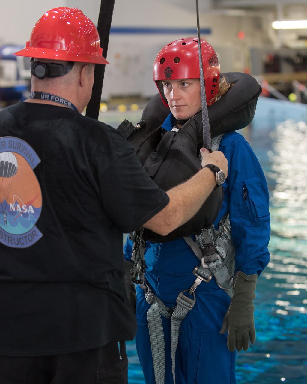 jsc2017e111780 (08-23-2017) --- During water survival training in 2017 at NASA Johnson Space Center’s Neutral Buoyancy Laboratory in Houston, NASA astronaut candidate Loral O’Hara is fitted for training gear by  instructors. Photo Credit: (NASA/David DeHoyos)