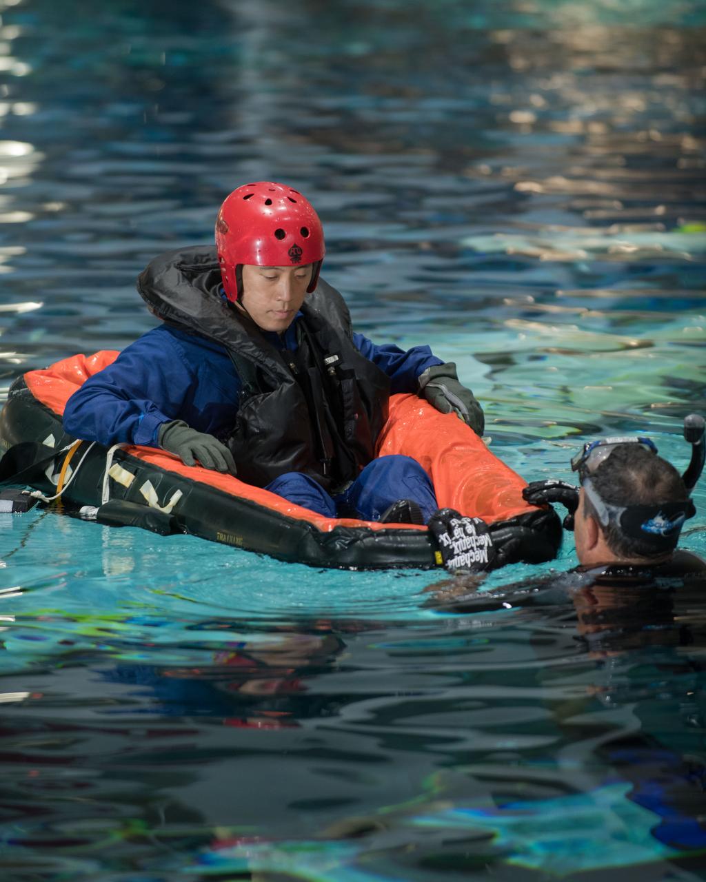 jsc2017e1117804 (08-23-2017) --- During water survival training in 2017 at NASA Johnson Space Center’s Neutral Buoyancy Laboratory in Houston, NASA astronaut candidate Jonny Kim (left) works alongside divers. Photo Credit: (NASA/David DeHoyos)