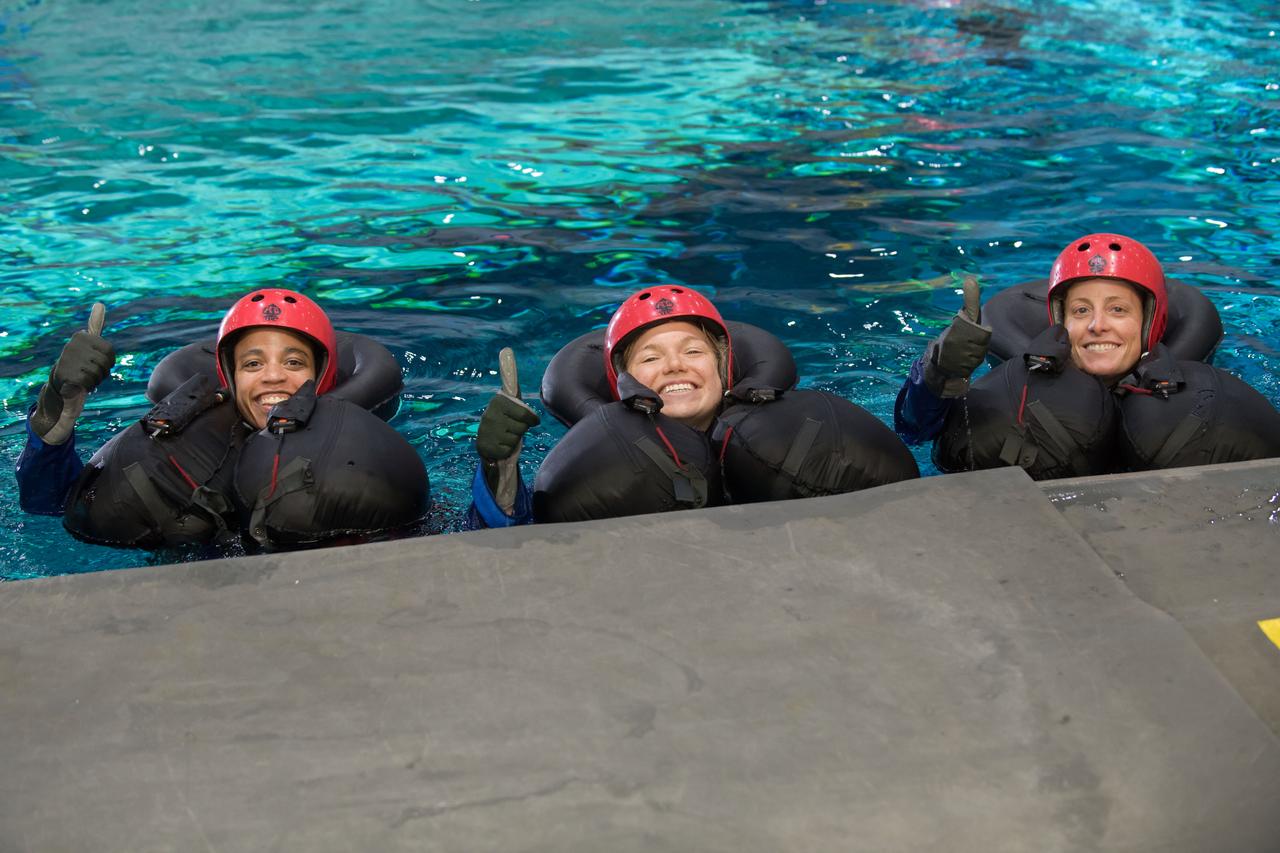 jsc2017e1117823 (08-23-2017) --- (From left) 2017 Astronaut candidates Jessica Watkins of NASA, Jennifer Sidey-Gibbons of CSA, and Loral O’Hara of NASA give a thumbs up after successful water survival training at NASA Johnson Space Center’s Neutral Buoyancy Laboratory in Houston. Photo Credit: (NASA/David DeHoyos)
