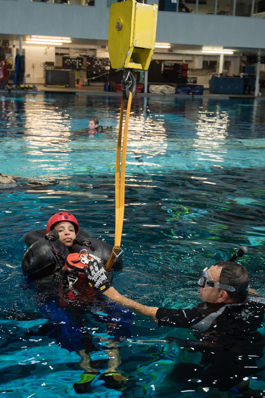 jsc2017e1117884 (08-23-2017) --- During water survival training in 2017 at NASA Johnson Space Center’s Neutral Buoyancy Laboratory in Houston, NASA astronaut candidate Jessica Watkins is guided through training by divers. Photo Credit: (NASA/David DeHoyos)