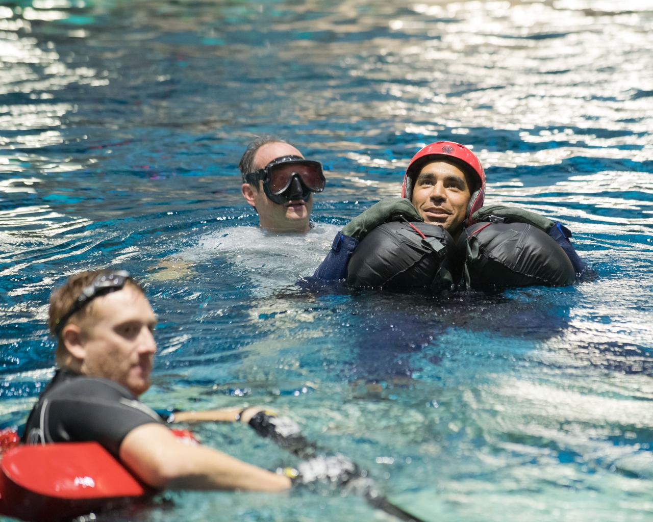 jsc2017e114927 (09-06-17) --- During water survival training in 2017 at NASA Johnson Space Center’s Neutral Buoyancy Laboratory in Houston, NASA astronaut candidate Raja Chari is guided through training by divers. Photo Credit: (NASA/James Blair)
