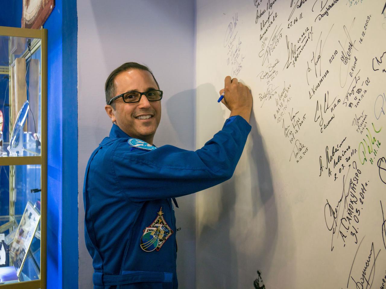 jsc2017e115132 (Sept. 7, 2017) --- In the Korolev Museum at the Baikonur Cosmodrome in Kazakhstan, Expedition 53-54 crewmember Joe Acaba of NASA signs a wall mural Sept. 7 as part of traditional pre-launch activities. Acaba, Mark Vande Hei of NASA and Alexander Misurkin of Roscosmos will launch Sept. 13 on the Soyuz MS-06 spacecraft for a five and a half month mission on the International Space Station. Credit: NASA/Victor Zelentsov