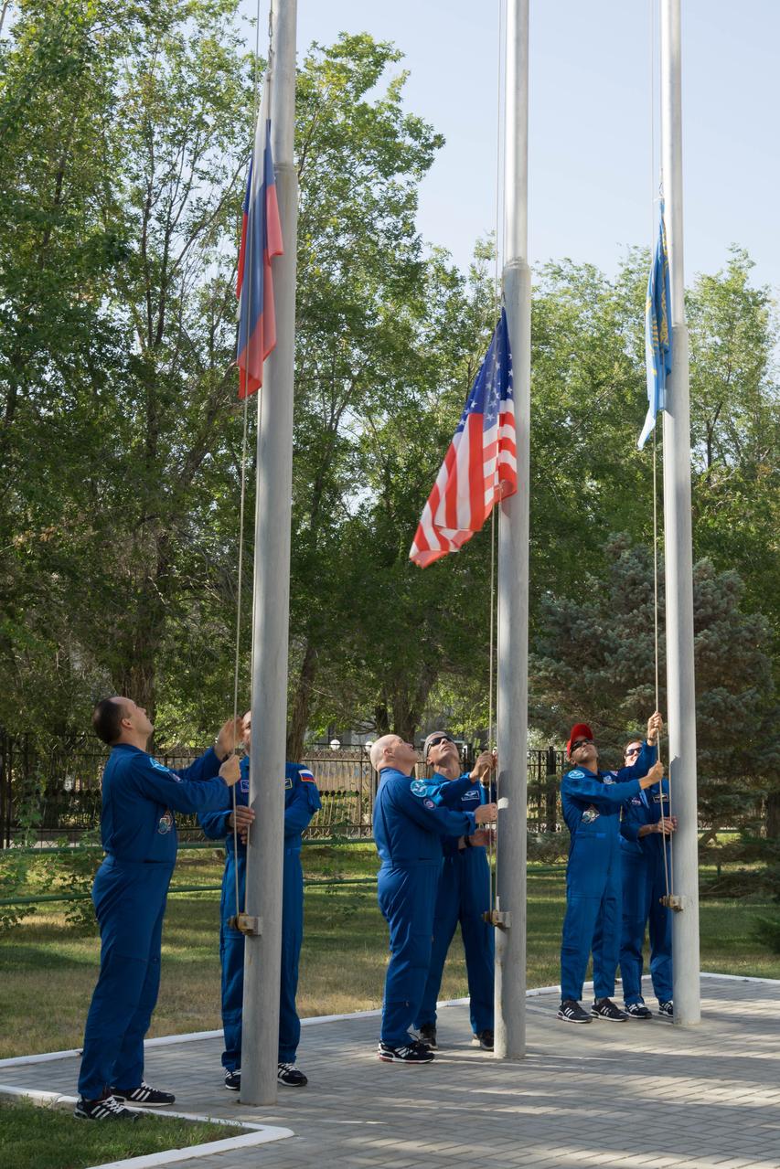 jsc2017e115136 (Sept. 7, 2017) --- At their Cosmonaut Hotel crew quarters in Baikonur, Kazakhstan, the Expedition 53-54 prime and backup crewmembers raise the flags of the United States, Russia and Kazakhstan Sept. 7 during traditional pre-launch ceremonies. Joe Acaba of NASA, Alexander Misurkin of Roscosmos and Mark Vande Hei of NASA will launch Sept. 13 on the Soyuz MS-06 spacecraft for a five and a half month mission on the International Space Station. Credit: NASA/Victor Zelentsov