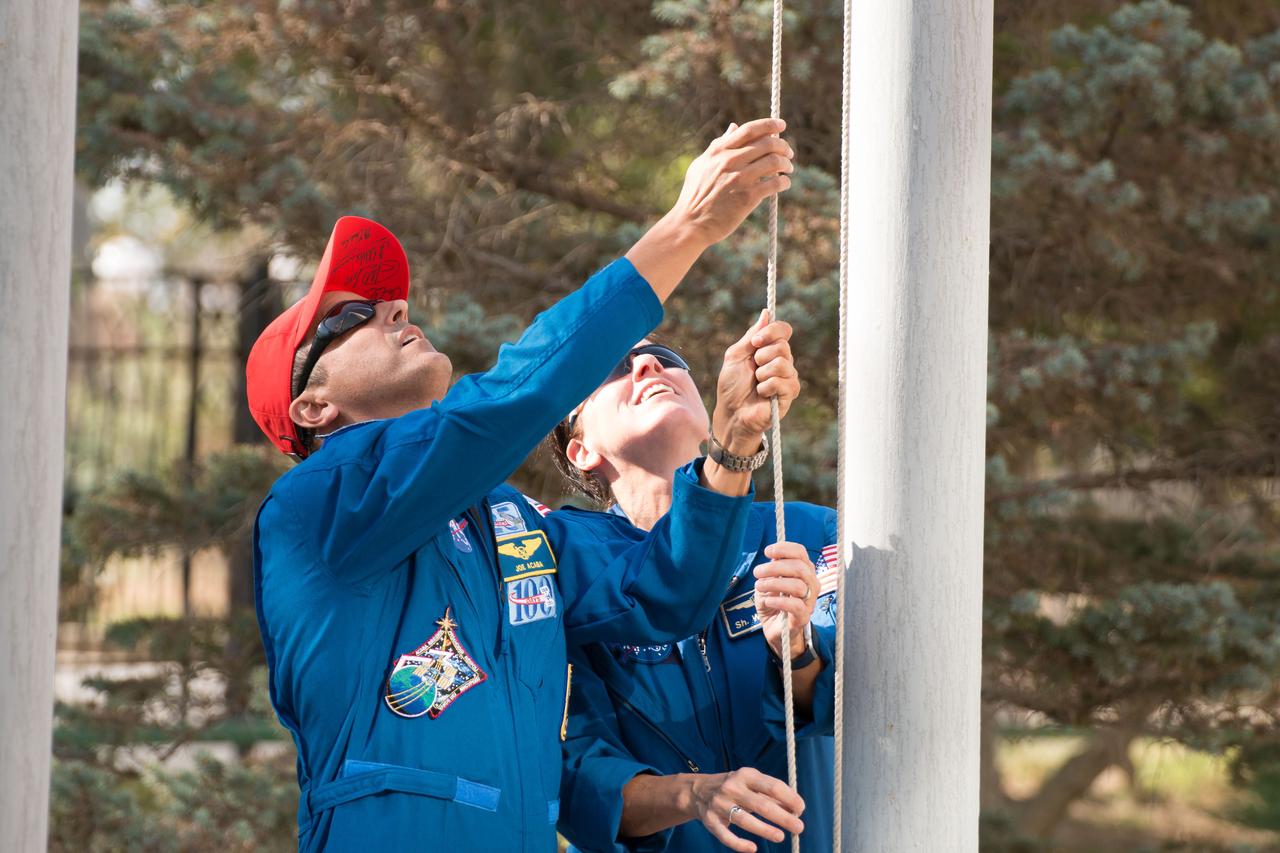 jsc2017e115137 (Sept. 7, 2017) --- At their Cosmonaut Hotel crew quarters in Baikonur, Kazakhstan, Expedition 53-54 prime and backup crewmembers Joe Acaba of NASA (left) and Shannon Walker of NASA (right) raise the United States flag Sept. 7 during traditional pre-launch ceremonies. Acaba, Alexander Misurkin of Roscosmos and Mark Vande Hei of NASA will launch Sept. 13 on the Soyuz MS-06 spacecraft for a five and a half month mission on the International Space Station. Credit: NASA/Victor Zelentsov