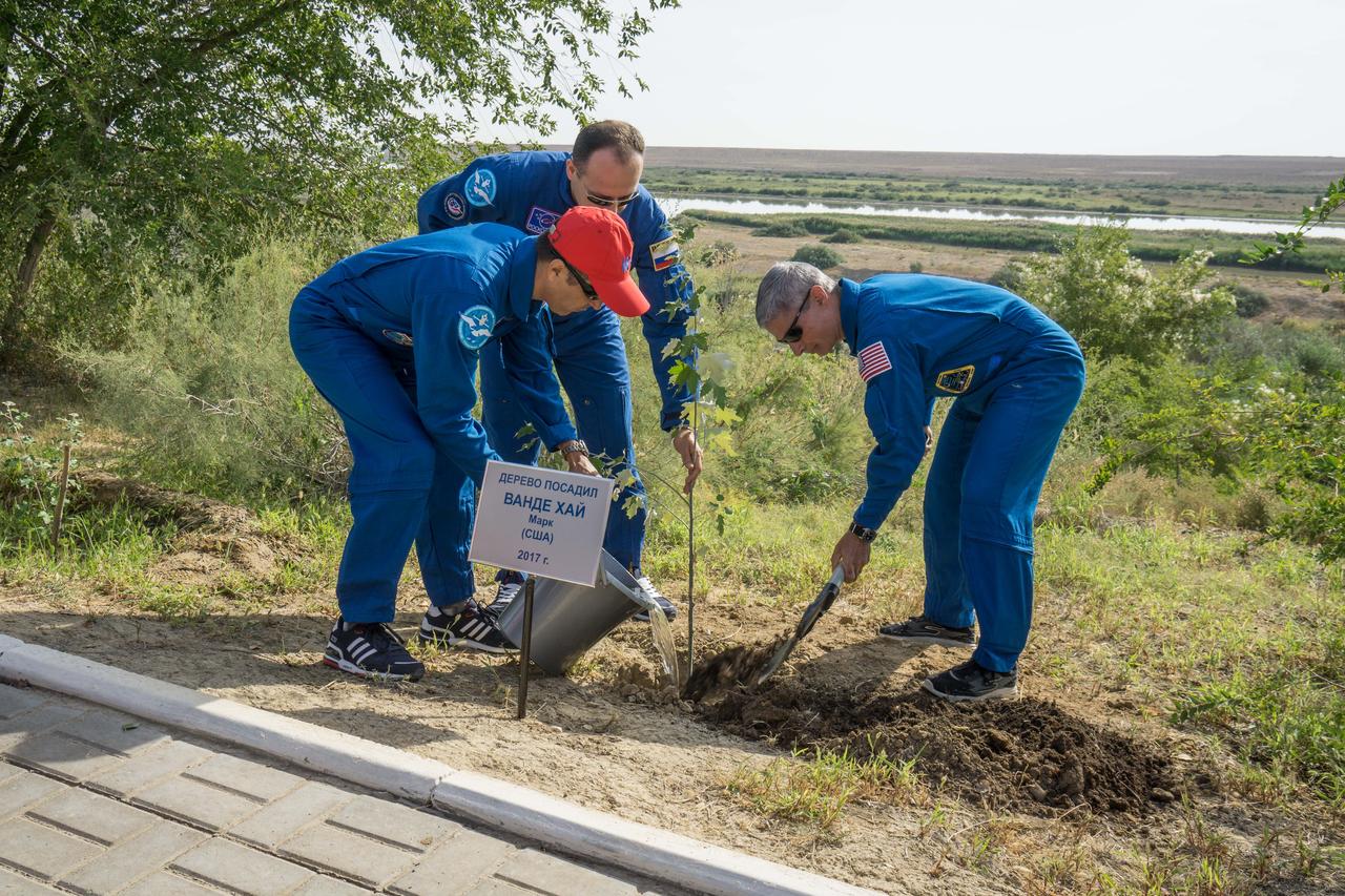 jsc2017e115211 (Sept.. 8, 2017) --- At the Cosmonaut Hotel crew quarters in Baikonur, Kazakhstan, Expedition 53-54 crewmember Mark Vande Hei of NASA (right) plants a tree bearing his name Sept. 8 in a traditional pre-launch ceremony as crewmates Joe Acaba of NASA (left) and Alexander Misurkin of Roscosmos (center) pitch in to help. Acaba, Misurkin and Vande Hei will launch Sept. 13 from the Baikonur Cosmodrome in Kazakhstan on the Soyuz MS-06 spacecraft for a five and a half month mission on the International Space Station. Credit: NASA/Victor Zelentsov