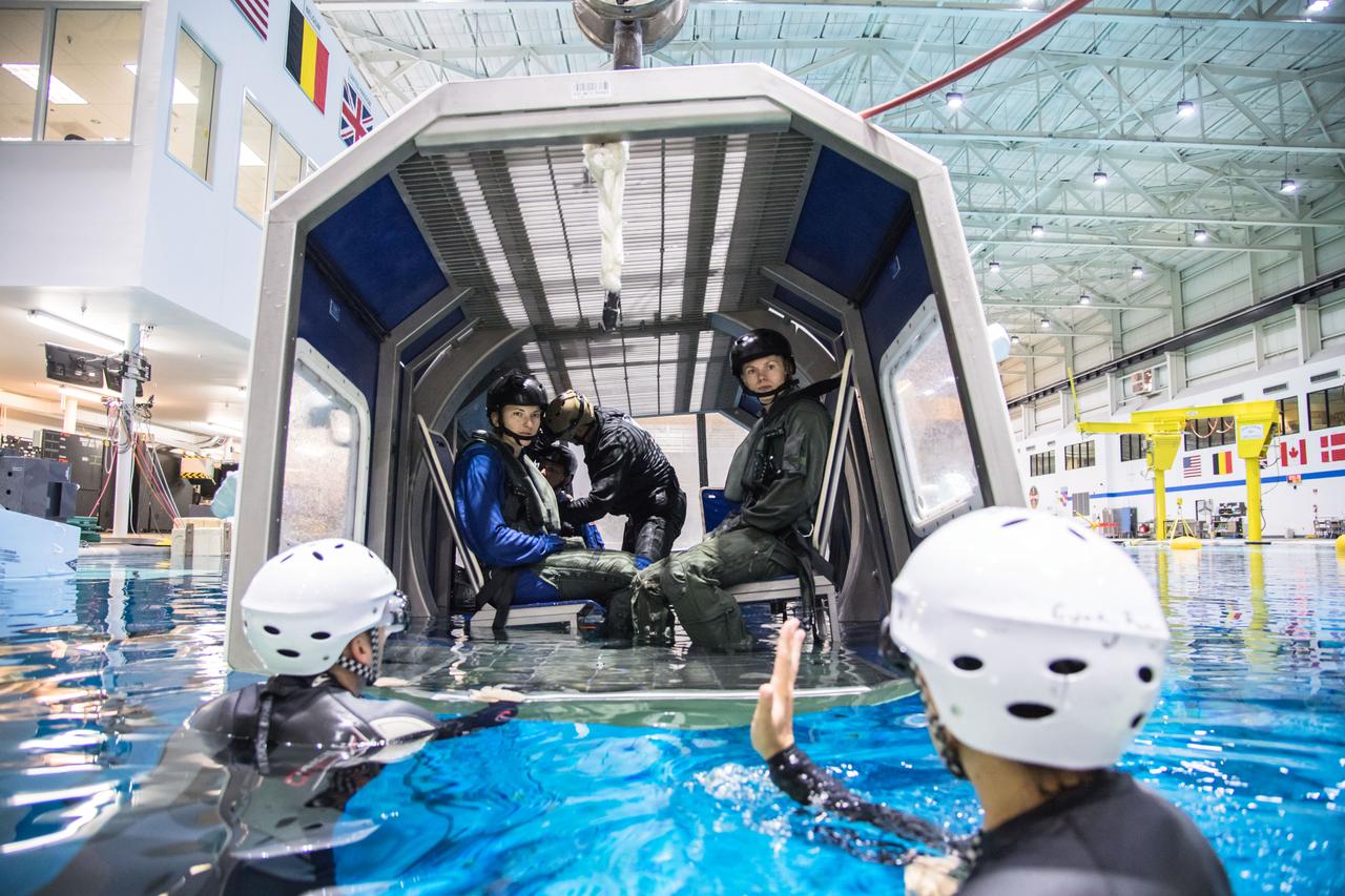 jsc2017e118980 (September 21, 2017) --- 2017 NASA astronaut candidates Kayla Barron (left) and Zena Cardman (right) receive guidance from training instructors during helicopter water survival training at NASA Johnson Space Center’s Neutral Buoyancy Laboratory in Houston. Photo Credit: (NASA/Josh Valcarcel)
