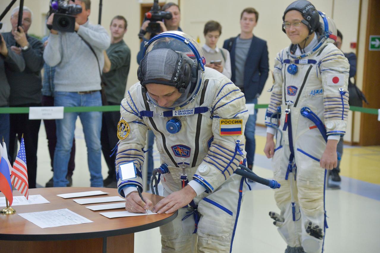 jsc2017e135200 - At the Gagarin Cosmonaut Training Center in Star City, Russia, Expedition 54-55 prime crewmember Anton Shkaplerov of the Russian Federal Space Agency (Roscosmos) signs in for the start of the crew’s final qualification exam activities Nov. 29 as crewmate Norishige Kanai of the Japan Aerospace Exploration Agency (JAXA) looks on. Shkaplerov, Kanai and Scott Tingle of NASA will launch Dec. 17 on the Soyuz MS-07 spacecraft from the Baikonur Cosmodrome in Kazakhstan for a five-month mission on the International Space Station...NASA/Elizabeth Weissinger.