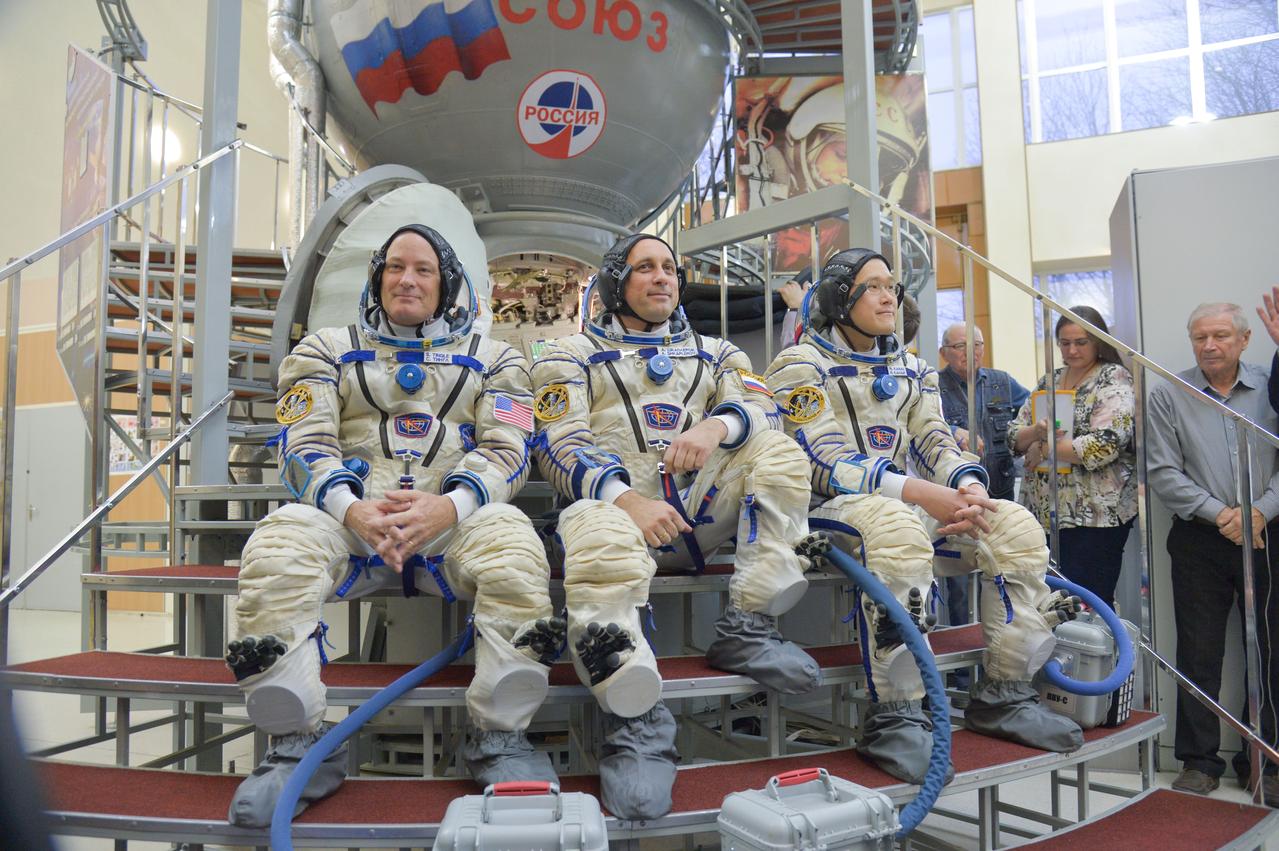 jsc2017e135204 - At the Gagarin Cosmonaut Training Center in Star City, Russia, Expedition 54-55 prime crewmembers Scott Tingle of NASA (left) Anton Shkaplerov of the Russian Federal Space Agency (Roscosmos, center) and Norishige Kanai of the Japan Aerospace Exploration Agency (JAXA, right) pose for pictures Nov. 29 in front of a Soyuz spacecraft simulator as part of their final crew qualification exam activities. They will launch Dec. 17 on the Soyuz MS-07 spacecraft from the Baikonur Cosmodrome in Kazakhstan for a five-month mission on the International Space Station...NASA/Elizabeth Weissinger.