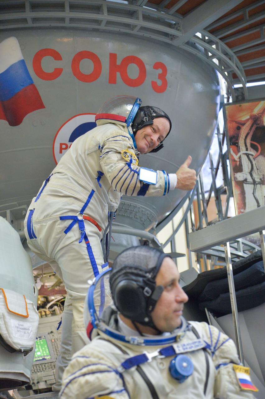 jsc2017e135209 - At the Gagarin Cosmonaut Training Center in Star City, Russia, Expedition 54-55 prime crewmember Scott Tingle of NASA flashes a thumbs up as he boards a Soyuz spacecraft simulator Nov. 29 as part of the crew’s final qualification exam activities. Anton Shkaplerov of the Russian Federal Space Agency (Roscosmos) is seen in the foreground. They will launch along with Norishige Kanai of the Japan Aerospace Exploration Agency (JAXA) Dec. 17 on the Soyuz MS-07 spacecraft from the Baikonur Cosmodrome in Kazakhstan for a five-month mission on the International Space Station...NASA/Elizabeth Weissinger.