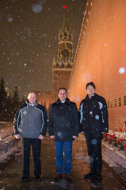 jsc2017e136056 - On a snowy night at Red Square in Moscow, Expedition 54-55 crewmembers Scott Tingle of NASA (left), Anton Shkaplerov of the Russian Federal Space Agency (Roscosmos, center) and Norishige Kanai of the Japan Aerospace Exploration Agency (JAXA, right) pose for pictures at the Kremlin Wall where Russian space icons are interred in traditional pre-launch ceremonies Nov. 30. They will launch from the Baikonur Cosmodrome in Kazakhstan on the Soyuz MS-07 spacecraft Dec. 17 for a five-month mission on the International Space Station...Andrey Shelepin/Gagarin Cosmonaut Training Center.