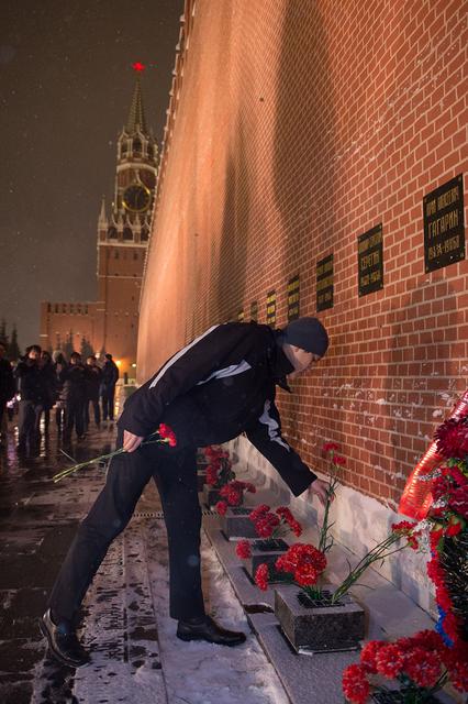 jsc2017e136060 - On a snowy night at Red Square in Moscow, Expedition 54-55 crewmember Norishige Kanai of the Japan Aerospace Exploration Agency (JAXA) lays flowers at the Kremlin Wall where Russian space icons are interred in traditional pre-launch ceremonies Nov. 30. Kanai, Scott Tingle of NASA and Anton Shkaplerov of the Russian Federal Space Agency (Roscosmos) will launch from the Baikonur Cosmodrome in Kazakhstan on the Soyuz MS-07 spacecraft Dec. 17 for a five-month mission on the International Space Station...Andrey Shelepin/Gagarin Cosmonaut Training Center.