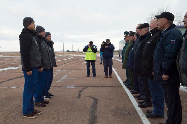 jsc2017e136099 - Expedition 54-55 crewmembers Norishige Kanai of the Japan Aerospace Exploration Agency (JAXA, left), Anton Shkaplerov of the Russian Federal Space Agency (Roscosmos, center) and Scott Tingle of NASA report to Russian space officials upon their arrival Dec. 4 at their launch site at the Baikonur Cosmodrome in Kazakhstan. They will launch Dec. 17 on the Soyuz MS-07 spacecraft for a five-month mission on the International Space Station...Andrey Shelepin/Gagarin Cosmonaut Training Center.