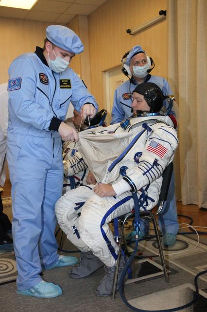 jsc2017e136440 - In the Integration Facility at the Baikonur Cosmodrome in Kazakhstan, Expedition 54-55 crewmember Scott Tingle of NASA suits up Dec. 5 for the first fit check dress rehearsal activity in the Soyuz MS-07 spacecraft. Tingle, Anton Shkaplerov of the Russian Federal Space Agency (Roscosmos) and Norishige Kanai of the Japan Aerospace Exploration Agency (JAXA), will launch Dec. 17 in the Soyuz MS-07 vehicle for a five-month mission on the International Space Station...Courtesy of Roscosmos.