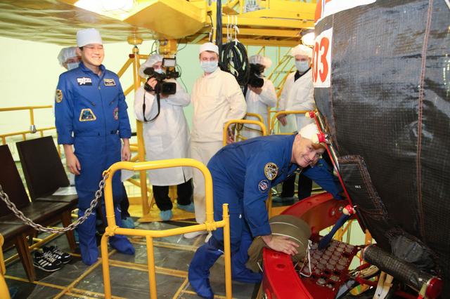 jsc2017e136446 - In the Integration Facility at the Baikonur Cosmodrome in Kazakhstan, Expedition 54-55 crewmember Scott Tingle of NASA (right) boards the Soyuz MS-07 spacecraft Dec. 5 as part of the first fit check dress rehearsal activities while crewmate Norishige Kanai of the Japan Aerospace Exploration Agency (JAXA, left) looks on. Tingle, Kanai and Anton Shkaplerov of the Russian Federal Space Agency (Roscosmos) will launch Dec. 17 in the Soyuz MS-07 vehicle for a five-month mission on the International Space Station...Courtesy of Roscosmos.