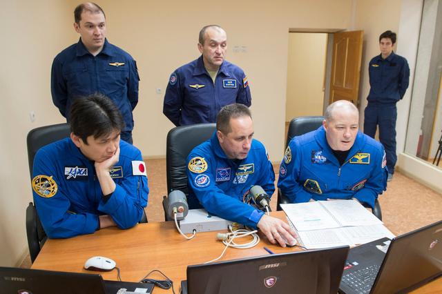 jsc2017e137334 - At their Cosmonaut Hotel crew quarters in Baikonur, Kazakhstan, Expedition 54-55 prime crewmembers Norishige Kanai of the Japan Aerospace Exploration Agency (JAXA, left), Anton Shkaplerov of the Russian Federal Space Agency (Roscosmos, center) and Scott Tingle of NASA (right) practice rendezvous and docking techniques on a laptop computer simulator Dec. 11 as part of their pre-launch training. They will launch Dec. 17 on the Soyuz MS-07 spacecraft from the Baikonur Cosmodrome for a five month mission on the International Space Station...Andrey Shelepin / Gagarin Cosmonaut Training Center.