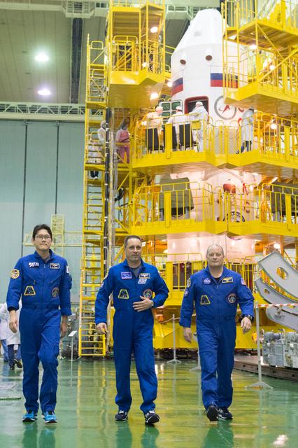 jsc2017e138122 - At the Integration Facility at the Baikonur Cosmodrome in Kazakhstan, Expedition 54-55 prime crewmembers Norishige Kanai of the Japan Aerospace Exploration Agency (JAXA, left), Anton Shkaplerov the Russian Federal Space Agency (Roscosmos, center) and Scott Tingle of NASA (right) walk from their Soyuz MS-07 spacecraft Dec. 13 at the conclusion of a second dress rehearsal fit check activity. They will launch Dec. 17 on the Soyuz MS-07 vehicle for a five month mission on the International Space Station...Andrey Shelepin/Gagarin Cosmonaut Training Center.