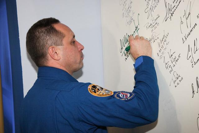 jsc2017e138123 - At the Korolev Museum at the Baikonur Cosmodrome in Kazakhstan, Expedition 54-55 prime crewmember Anton Shkaplerov of the Russian Federal Space Agency (Roscosmos) signs a wall mural Dec. 13 as part of traditional pre-launch ceremonies. Shkaplerov, Scott Tingle of NASA and Norishige Kanai of the Japan Aerospace Exploration Agency (JAXA) will launch Dec. 17 on the Soyuz MS-07 spacecraft for a five month mission on the International Space Station...Andrey Shelepin/Gagarin Cosmonaut Training Center.