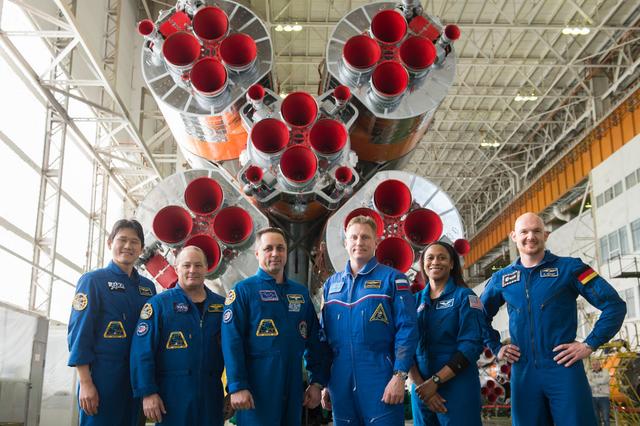 jsc2017e138124 - In the Integration Facility at the Baikonur Cosmodrome in Kazakhstan, the Expedition 54-55 prime and backup crewmembers pose for pictures Dec. 13 in front of the first stage of the Soyuz booster rocket. From left to right are prime crewmembers Norishige Kanai of the Japan Aerospace Exploration Agency (JAXA), Scott Tingle of NASA and Anton Shkaplerov of the Russian Federal Space Agency (Roscosmos), and backup crewmembers Sergey Prokopyev of Roscosmos, Jeanette Epps of NASA and Alexander Gerst of the European Space Agency. Kanai, Tingle and Shkaplerov will launch Dec. 17 on the Soyuz MS-07 spacecraft for a five month mission on the International Space Station...Andrey Shelepin/Gagarin Cosmonaut Training Center.