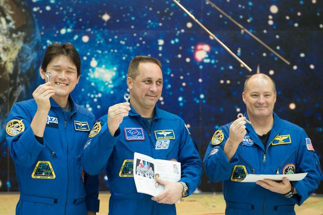 jsc2017e138125 - At the Korolev Museum at the Baikonur Cosmodrome in Kazakhstan, Expedition 54-55 prime crewmembers Norishige Kanai of the Japan Aerospace Exploration Agency (JAXA, left), Anton Shkaplerov of the Russian Federal Space Agency (Roscosmos, center) and Scott Tingle of NASA (right) display souvenir “launch keys) during traditional pre-flight ceremonies Dec. 13. They will launch Dec. 17 on the Soyuz MS-07 spacecraft for a five month mission on the International Space Station...Andrey Shelepin/Gagarin Cosmonaut Training Center.