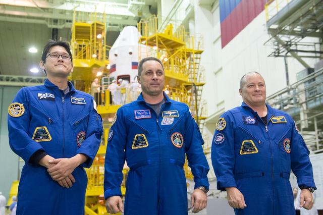 jsc2017e138128 - At the Integration Facility at the Baikonur Cosmodrome in Kazakhstan, Expedition 54-55 prime crewmembers Norishige Kanai of the Japan Aerospace Exploration Agency (JAXA, left), Anton Shkaplerov the Russian Federal Space Agency (Roscosmos, center) and Scott Tingle of NASA (right) answer reporters’ questions in front of the Soyuz MS-07 spacecraft Dec. 13 at the conclusion of a second dress rehearsal fit check activity. They will launch Dec. 17 on the Soyuz MS-07 vehicle for a five month mission on the International Space Station...Andrey Shelepin/Gagarin Cosmonaut Training Center.