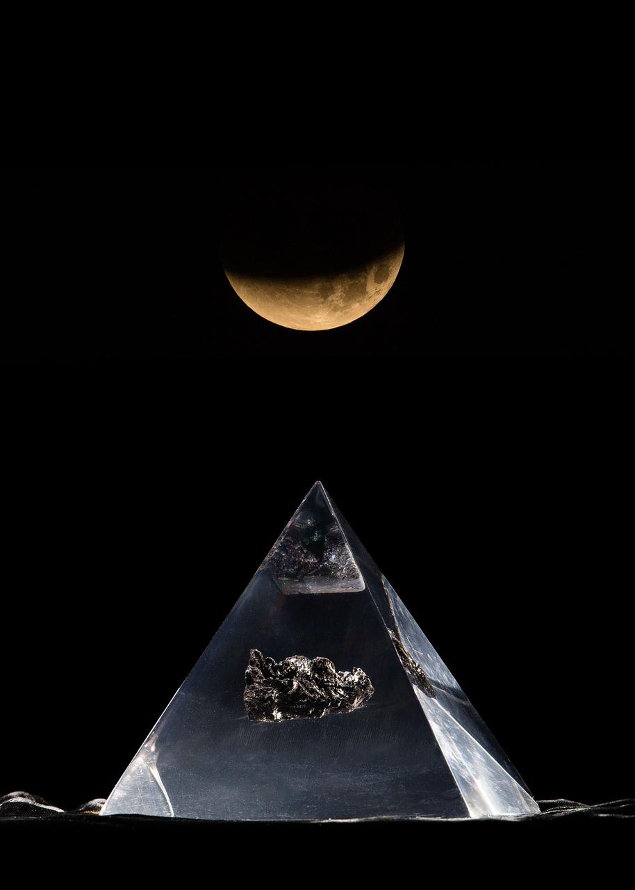 jsc2018e003239_alt (Jan. 31, 2018) --- Composite image of an Apollo lunar sample in front of the lunar eclipse "Blood Moon". Credit: NASA/Josh Valcarcel