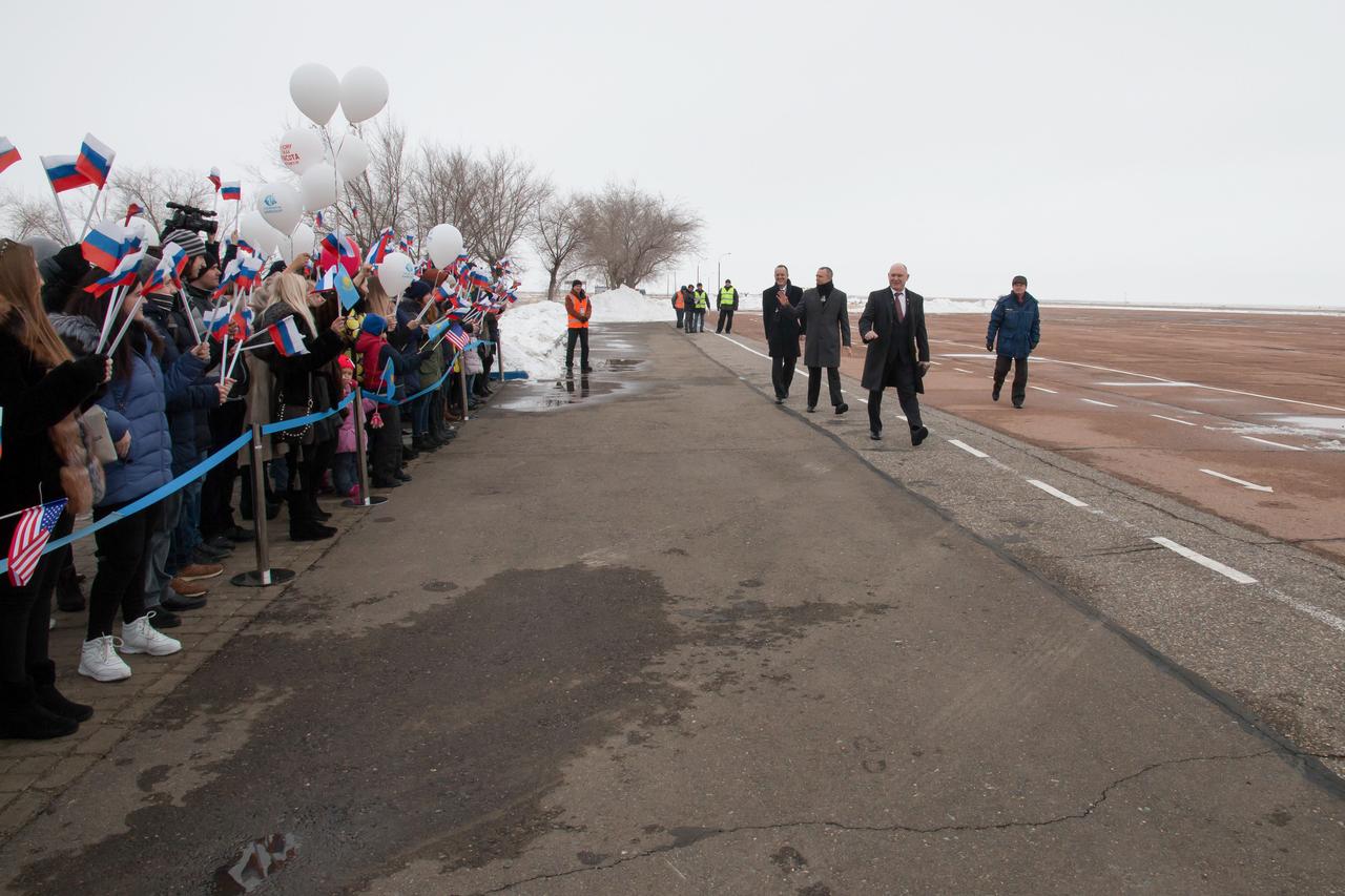 jsc2018e010816 - Expedition 55 crewmembers Ricky Arnold of NASA, Oleg Artemyev of Roscosmos and Drew Feustel of NASA are greeted by local school children in Baikonur, Kazakhstan after their arrival March 4 following a flight from their training base outside of Moscow. The trio will launch March 21 on the Soyuz MS-08 spacecraft for a five month mission on the International Space Station...NASA/Victor Zelentsov.
