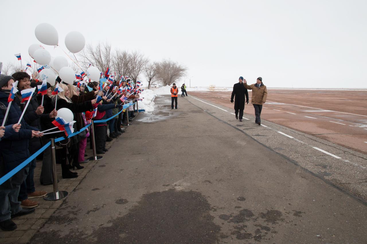 jsc2018e010819 - Expedition 55 backup crewmembers Nick Hague of NASA and Alexey Ovchinin of Roscosmos wave to local school children after arriving at the airstrip in Baikonur, Kazakhstan March 4 following a flight from their training base outside of Moscow. They are serving as backups to Ricky Arnold and Drew Feustel of NASA and Oleg Artemyev of Roscosmos, who will launch March 21 on the Soyuz MS-08 spacecraft for a five month mission on the International Space Station...NASA/Victor Zelentsov.