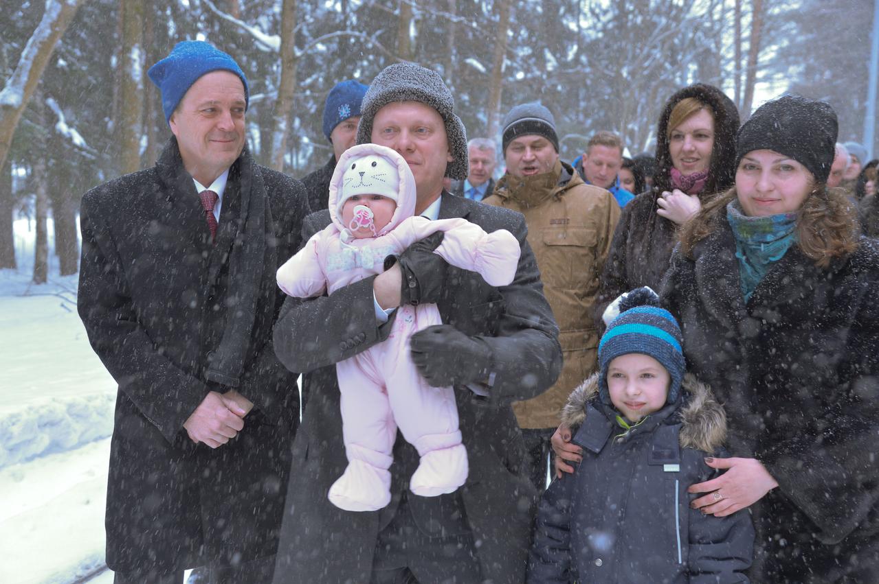 jsc2018e010820 - Bundled up against a blizzard, Expedition 55 crewmember Oleg Artemyev of Roscosmos holds his infant child March 4 at the Gagarin Cosmonaut Training Center in Star City, Russia as he and his family walk to a waiting bus to take them to a nearby airport for a flight to the launch site at the Baikonur Cosmodrome in Kazakhstan. Looking on is crewmate Ricky Arnold of NASA (left). Arnold, Artemyev and Drew Feustel of NASA will launch March 21 on the Soyuz MS-08 spacecraft for a five month mission on the International Space Station...NASA/Elizabeth Weissinger.