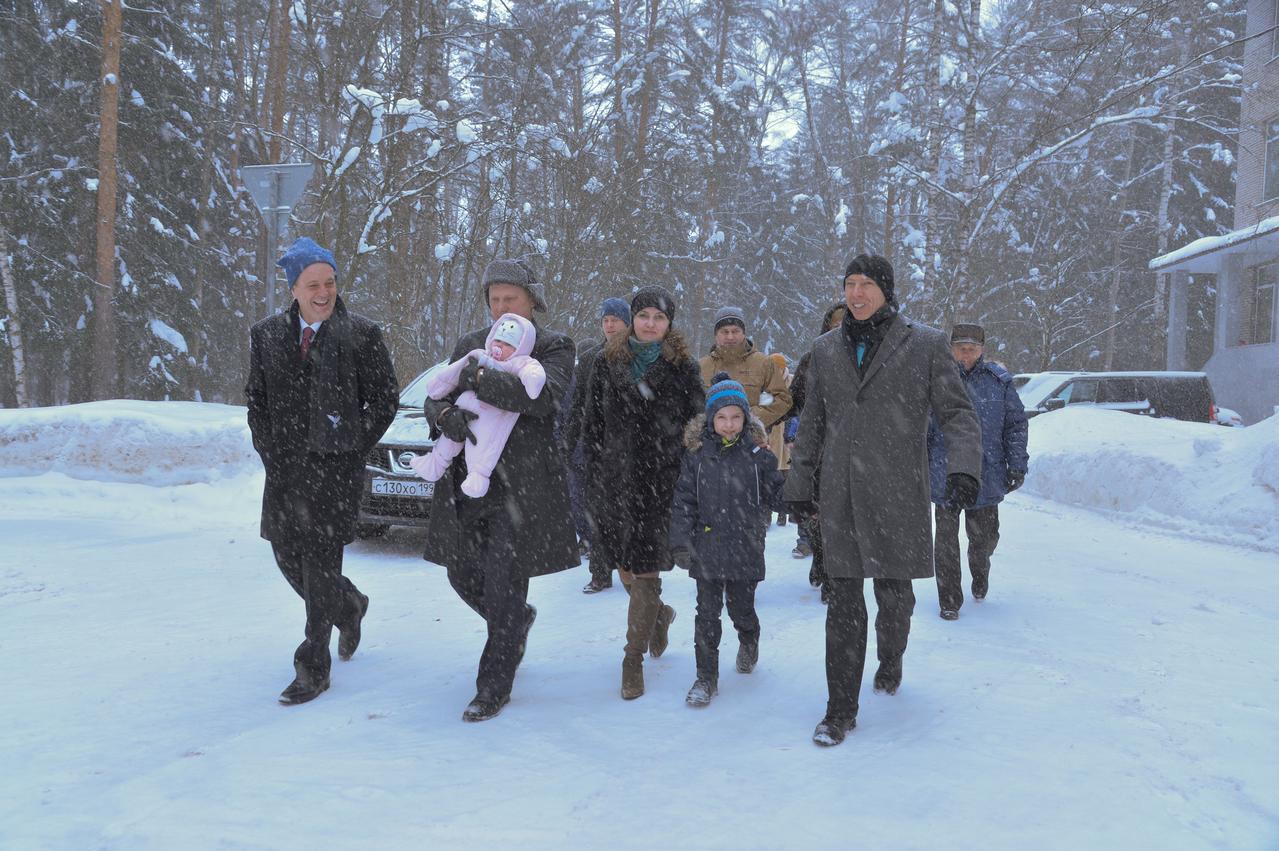 jsc2018e010821 - Bundled up against a blizzard, Expedition 55 crewmember Oleg Artemyev of Roscosmos (center) holds his infant child March 4 at the Gagarin Cosmonaut Training Center in Star City, Russia as he and his crewmates walk to a waiting bus to take them to a nearby airport for a flight to the launch site at the Baikonur Cosmodrome in Kazakhstan. Looking on are crewmates Ricky Arnold of NASA (left) and Drew Feustel of NASA (right). The trio will launch March 21 on the Soyuz MS-08 spacecraft for a five month mission on the International Space Station...NASA/Elizabeth Weissinger.