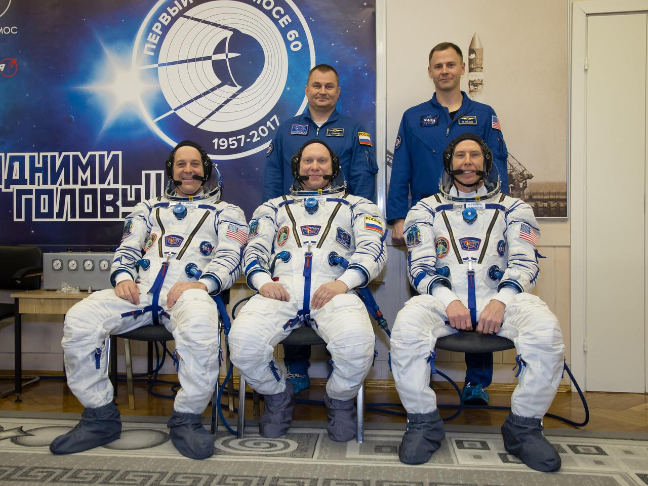 jsc2018e010873 - At the Baikonur Cosmodrome in Kazakhstan. Expedition 55 crewmembers Ricky Arnold of NASA (front row, left), Oleg Artemyev of Roscosmos (front row, center) and Drew Feustel of NASA (front row, right) pose for pictures March 5 during the crew’s first vehicle fit check activities. Behind them are the backup crewmembers, Alexey Ovchinin of Roscosmos (back row, left) and Nick Hague of NASA (back row, right). Arnold, Artemyev and Feustel will launch March 21 in the Soyuz MS-08 spacecraft from Baikonur for a five-month mission on the International Space Station...NASA/Victor Zelentsov.