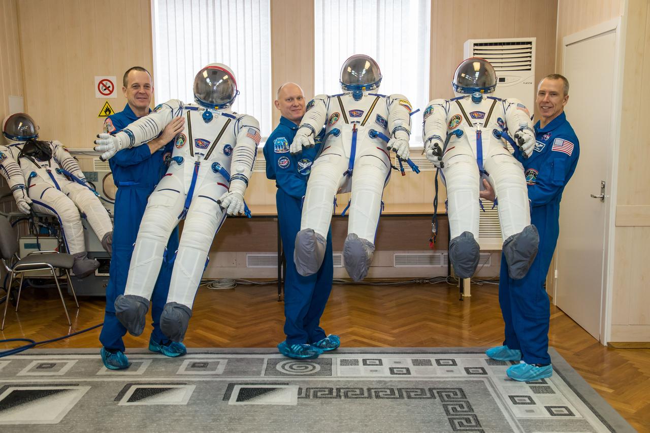 jsc2018e010883 - At the Baikonur Cosmodrome in Kazakhstan, Expedition 55 crewmembers Ricky Arnold of NASA (left), Oleg Artemyev of Roscosmos (center) and Drew Feustel of NASA (right) pose for pictures with their Russian Sokol launch and entry suits March 5 as part of the crew’s first vehicle fit check activities. They will launch March 21 in the Soyuz MS-08 spacecraft from Baikonur for a five-month mission on the International Space Station...NASA/Victor Zelentsov.