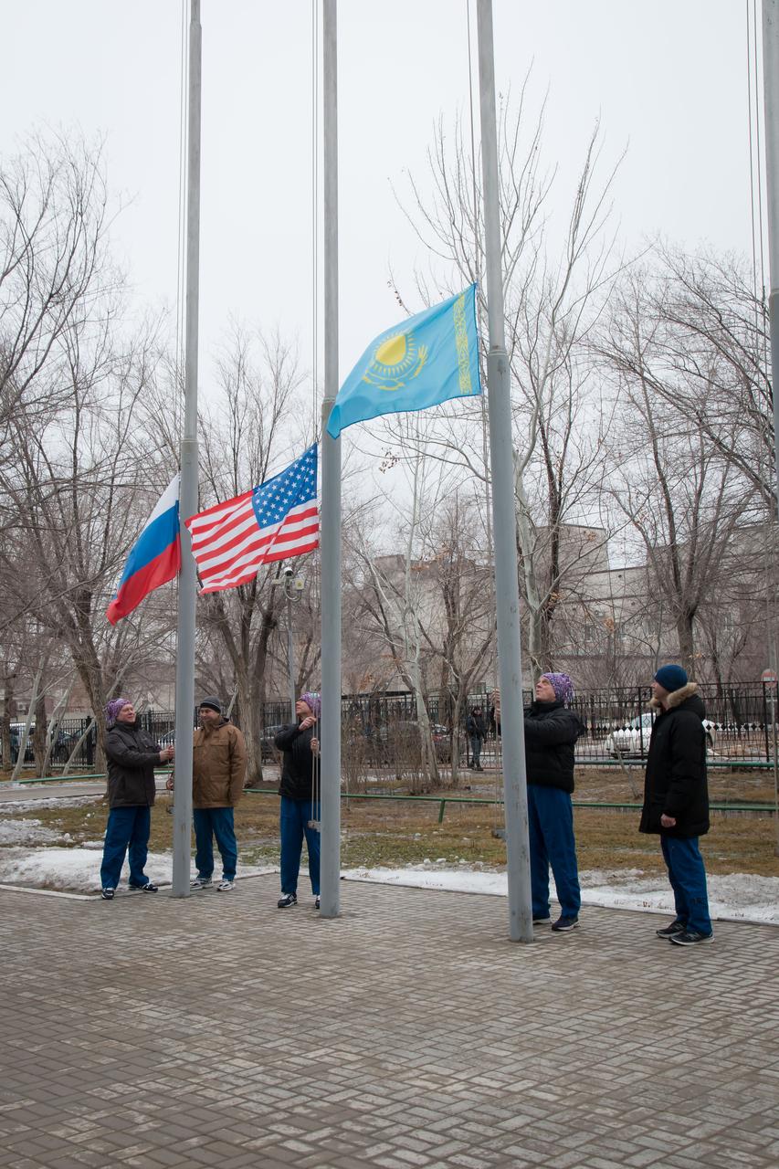 At their Cosmonaut Hotel crew quarters in Baikonur, Kazakhstan, the Expedition 55 prime and backup crewmembers raise the flags of Russia, the United States and Kazakhstan in traditional pre-launch ceremonies March 6. Drew Feustel and Ricky Arnold of NASA a