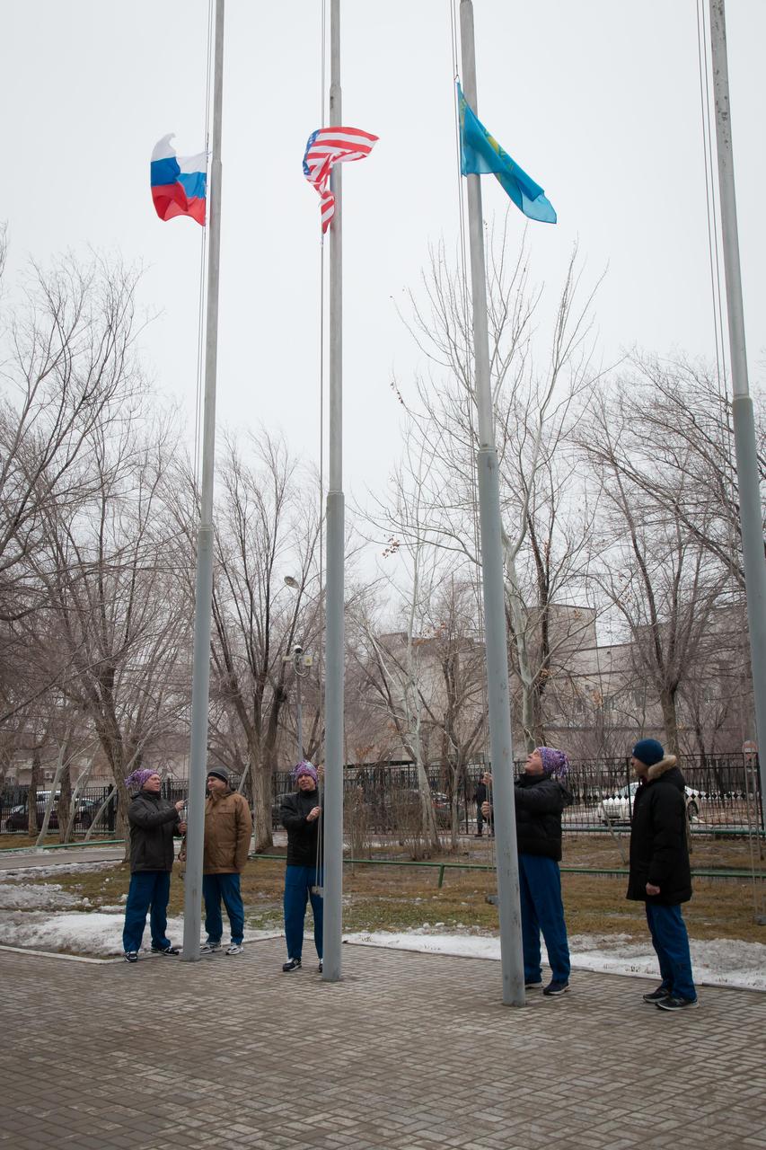 At their Cosmonaut Hotel crew quarters in Baikonur, Kazakhstan, the Expedition 55 prime and backup crewmembers raise the flags of Russia, the United States and Kazakhstan in traditional pre-launch ceremonies March 6. Prime crewmembers Drew Feustel and Rick