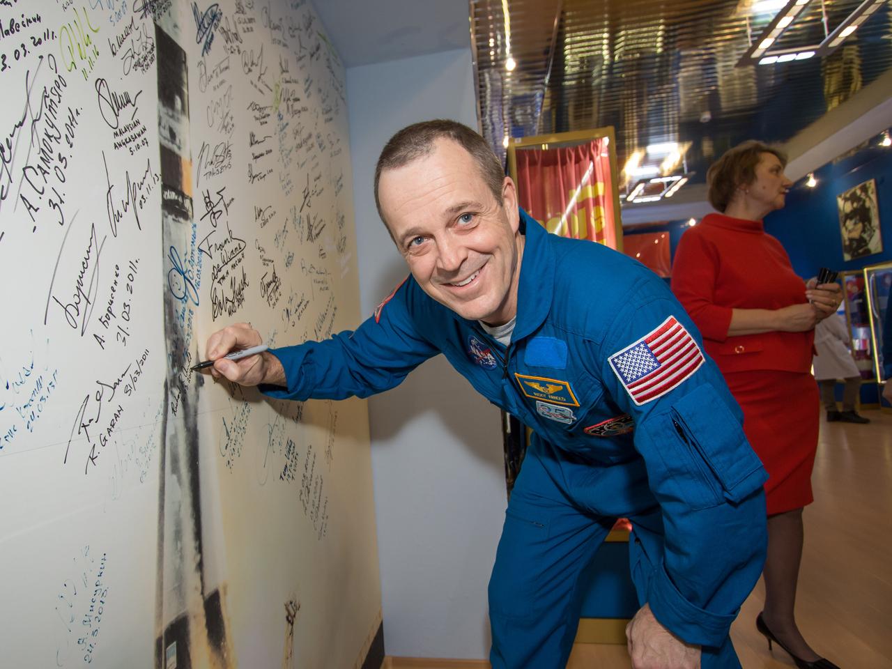 jsc2018e025592 - In the Korolev Museum at the Baikonur Cosmodrome in Kazakhstan, Expedition 55 crewmember Ricky Arnold of NASA signs a wall mural depicting a Soyuz launch March 16 as part of traditional prelaunch activities. Arnold, Oleg Artemyev of Roscosmos and Drew Feustel of NASA will launch March 21 on the Soyuz MS-08 spacecraft for a five-month mission on the International Space Station...NASA/Victor Zelentsov.