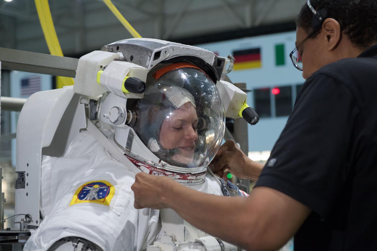 jsc2018e035783 (04-12-2018) --- NASA astronaut candidate Zena Cardman is being helped into a spacesuit for  underwater spacewalk training at NASA Johnson Space Center’s Neutral Buoyancy Laboratory. Photo Credit: (NASA/David DeHoyos)