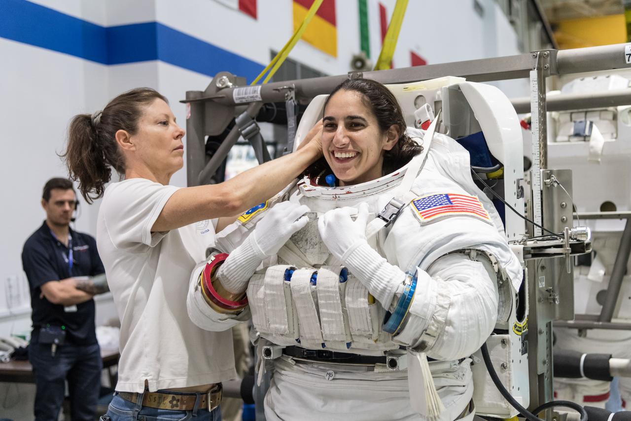 jsc2018e035915 (April 11, 2018) --- 2017 NASA astronaut candidate Jasmin Moghbeli is helped into a spacesuit prior to underwater spacewalk training at NASA Johnson Space Center’s Neutral Buoyancy Laboratory. Photo Credit: (NASA/Josh Valcarcel)