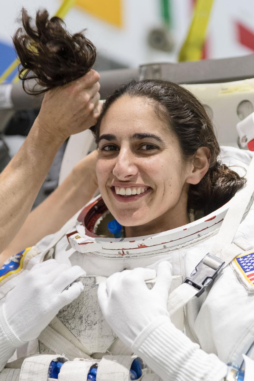 jsc2018e035916 (April 11, 2018) --- 2017 NASA astronaut candidate Jasmin Moghbeli is helped into a spacesuit prior to underwater spacewalk training at NASA Johnson Space Center’s Neutral Buoyancy Laboratory. Photo Credit: (NASA/Josh Valcarcel)