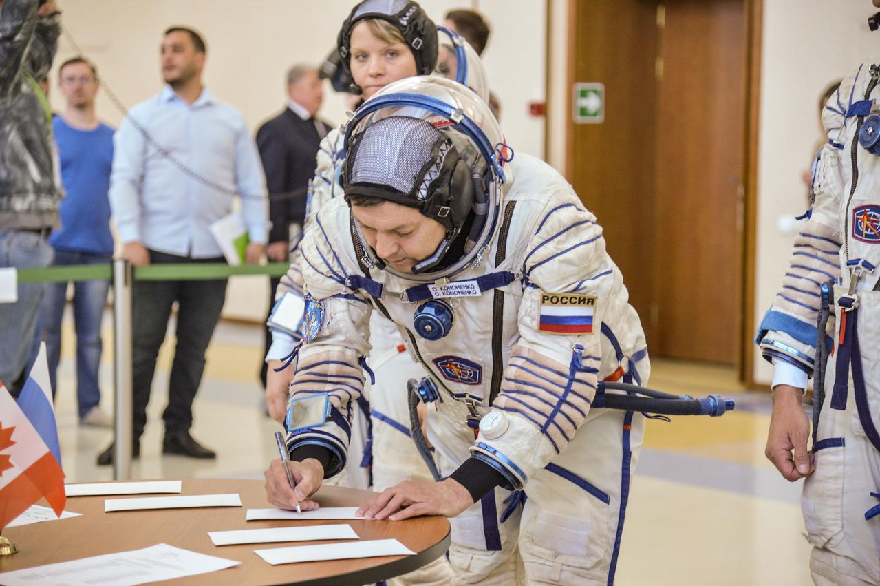 jsc2018e043404 (May 10, 2018) --- At the Gagarin Cosmonaut Training Center in Star City, Russia, Expedition 56 backup crew member Oleg Kononenko of Roscosmos signs in for the final Soyuz qualification exams May 10 as crewmate Anne McClain of NASA looks on. They and David Saint-Jacques of the Canadian Space Agency (right) are the backups to the prime crew of Serena Aunon-Chancellor of NASA, Sergey Prokopyev of Roscosmos and Alexander Gerst of the European Space Agency, who will launch June 6 from the Baikonur Cosmodrome in Kazakhstan on the Soyuz MS-09 spacecraft for a six-month mission on the International Space Station...NASA/Elizabeth Weissinger.