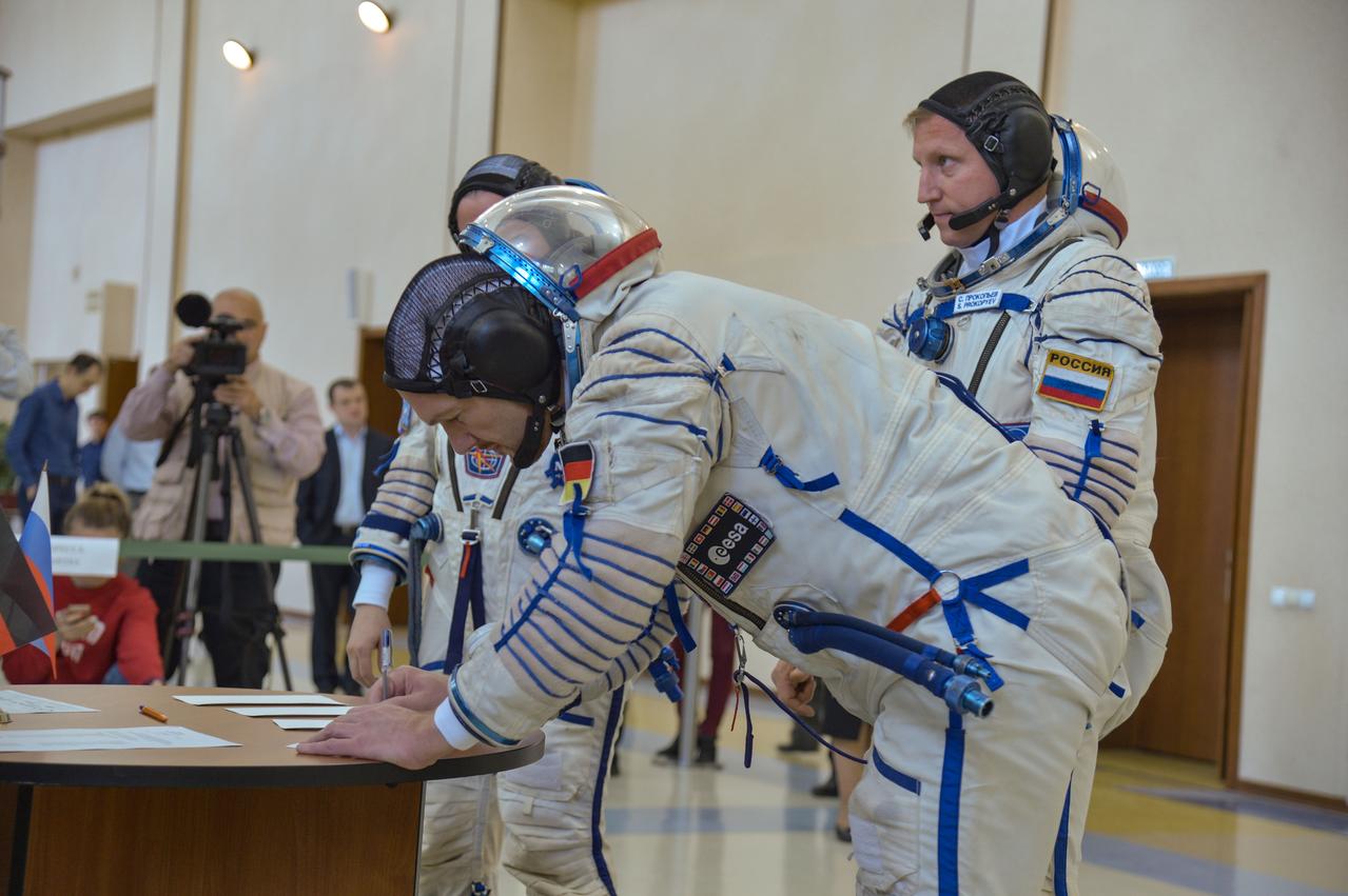 jsc2018e044092 - At the Gagarin Cosmonaut Training Center in Star City, Russia, Expedition 56 crewmember Alexander Gerst of the European Space Agency signs in for the final day of Soyuz qualification exams May 11 as his crewmate, Sergey Prokopyev of Roscosmos (right) looks on. Gerst, Prokopyev and Serena Aunon-Chancellor of NASA will launch June 6 on the Soyuz MS-09 spacecraft from the Baikonur Cosmodrome in Kazakhstan for a six-month mission on the International Space Station...NASA/Elizabeth Weissinger.