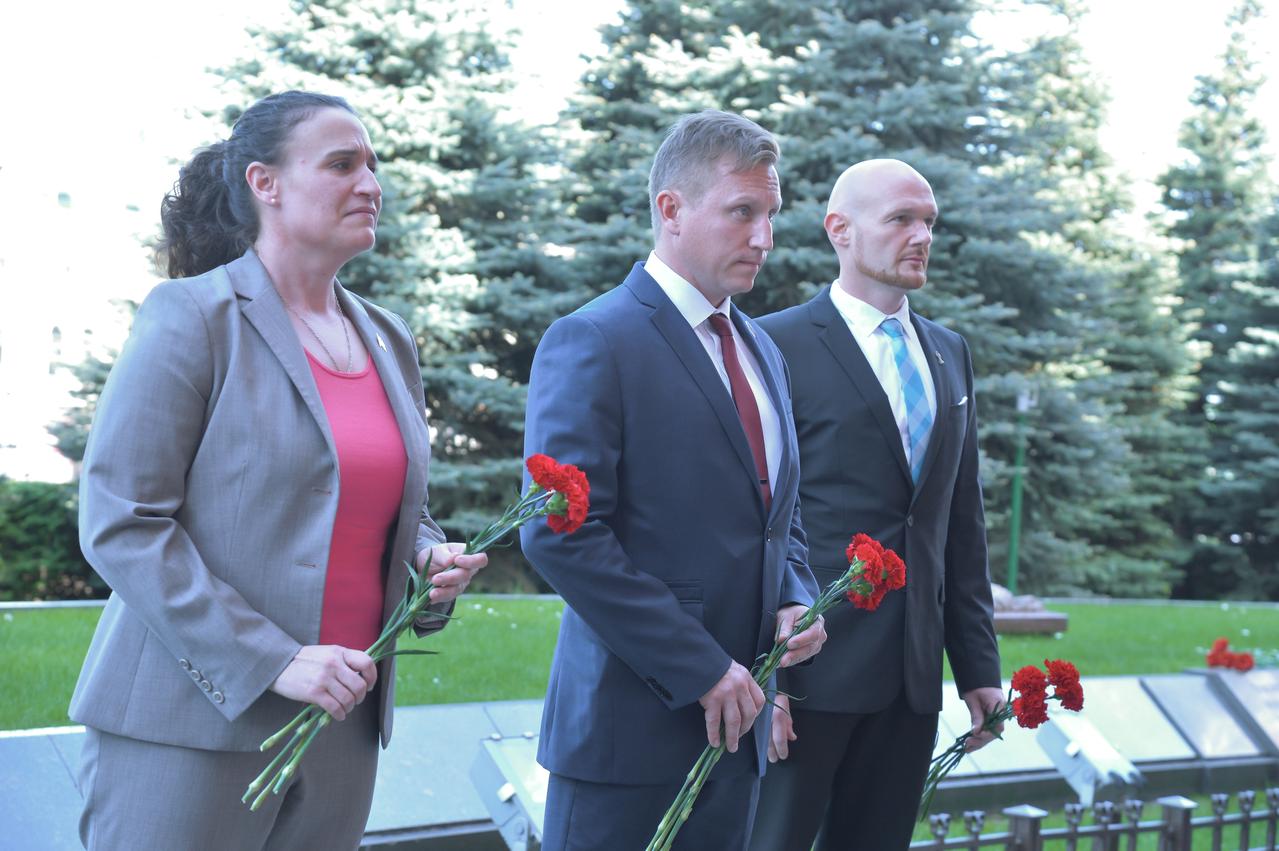 jsc2018e048502 - Pausing for a reflective moment at the Kremlin Wall at Red Square in Moscow May 14, Expedition 56 crewmembers Serena Aunon-Chancellor of NASA (left), Sergey Prokopyev of Roscosmos (center) and Alexander Gerst of the European Space Agency (right) prepare to lay flowers where Russian space icons are interred. They will launch June 6 from the Baikonur Cosmodrome in Kazakhstan on the Soyuz MS-09 spacecraft for a six month mission on the International Space Station...NASA/Elizabeth Weissinger.